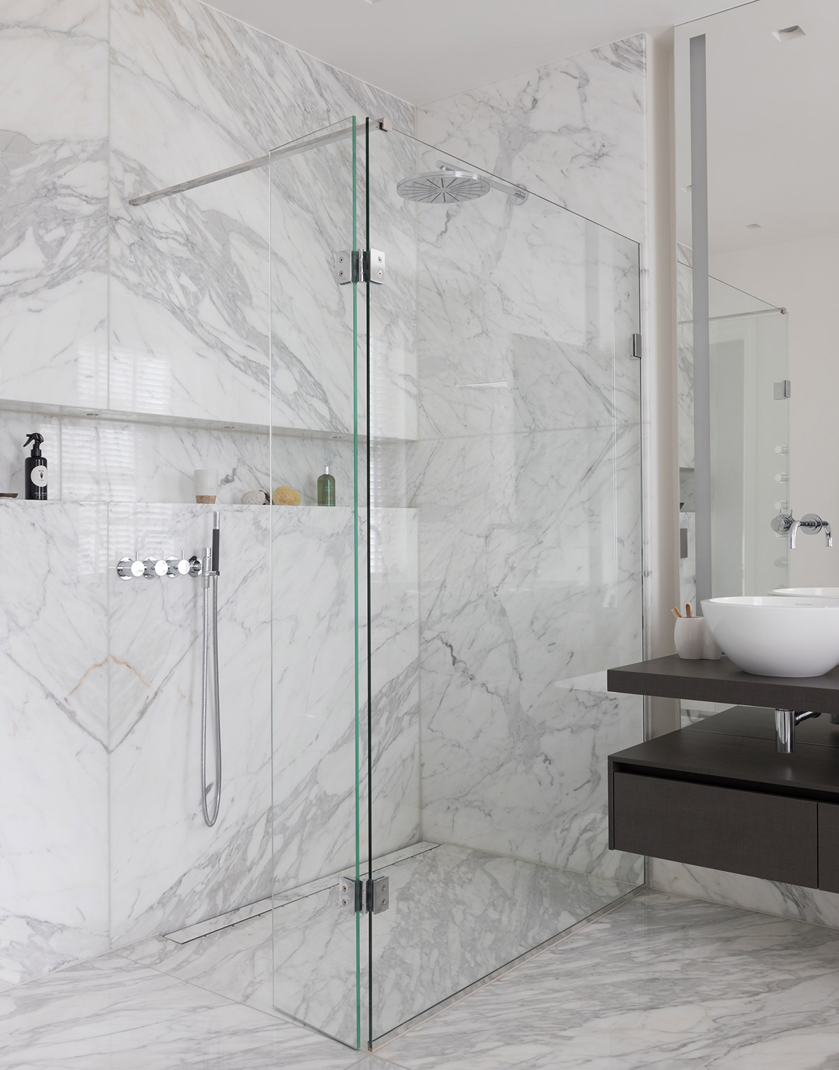 White marble carrara cladded bathroom with walk-in shower